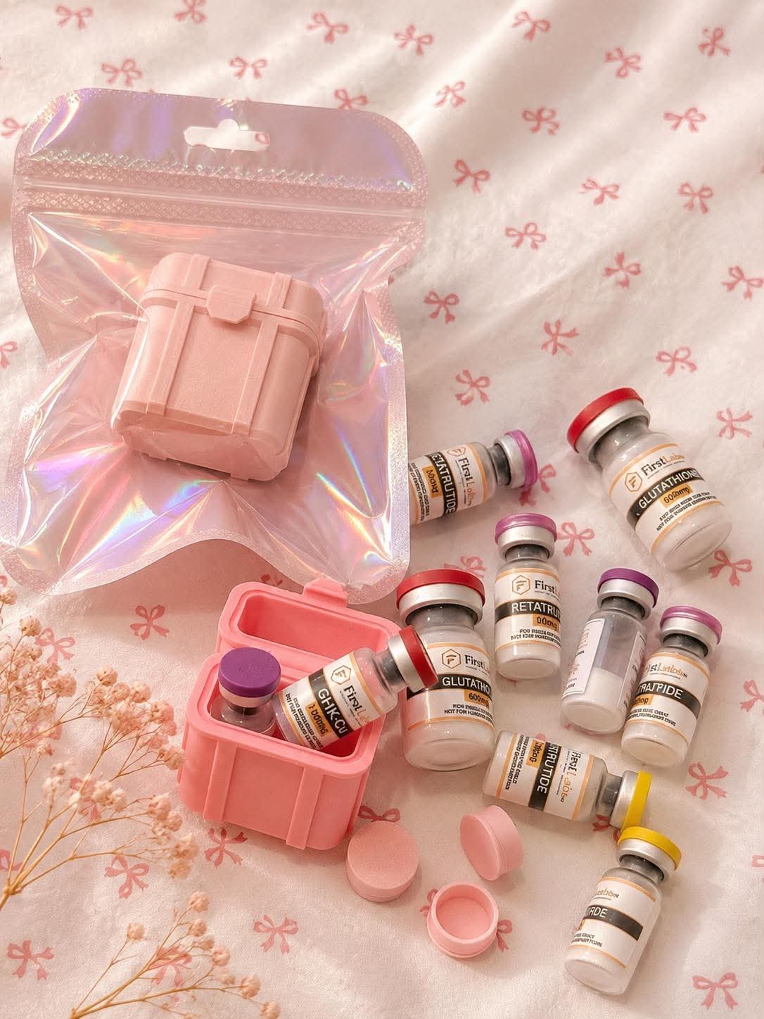FirstLabs PH vials with protective pink vial cases and holographic pouch flatlay