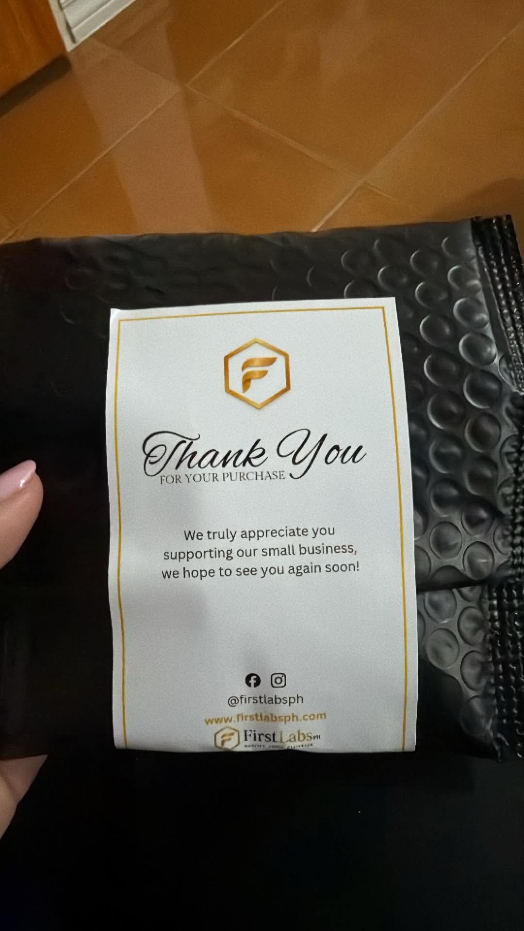 FirstLabs PH branded thank-you card on black bubble mailer