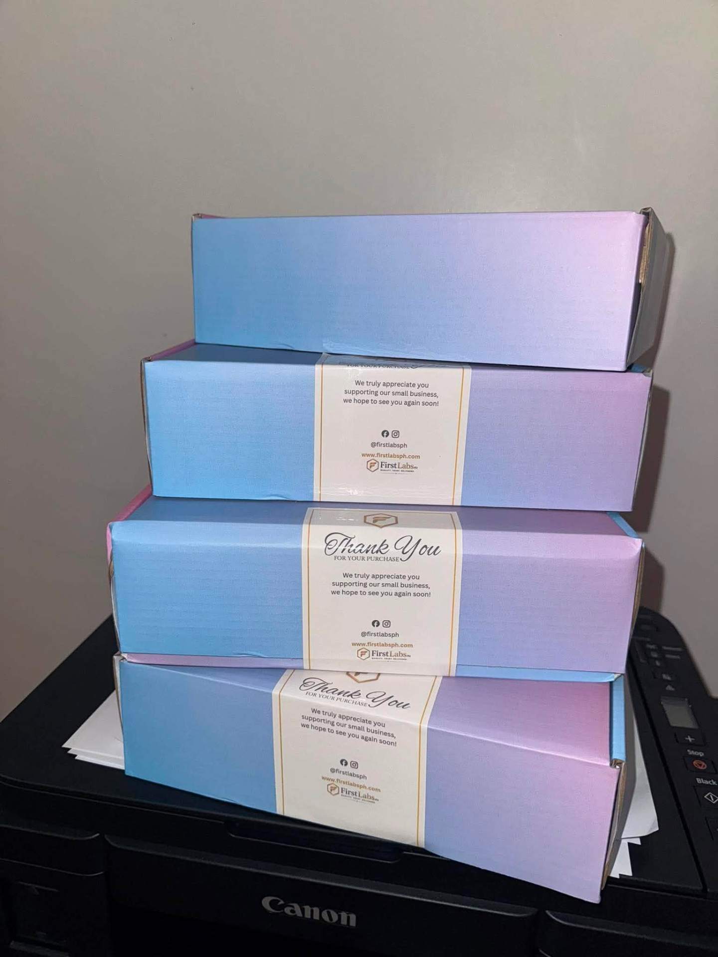 Stack of FirstLabs PH pastel gradient boxes with branded thank-you seals ready to ship